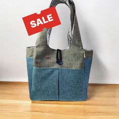 a handbag with a sale tag hanging from it's side on a wooden floor