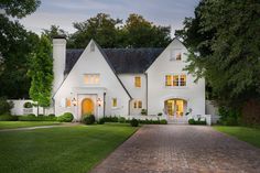 a large white house with a brick walkway leading to the front door