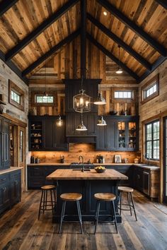 a large kitchen with wooden floors and black cabinetry, along with two bar stools