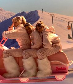 three people are riding in a pink sleigh