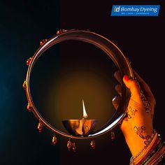 a woman holding a lit candle in front of her face with the words happy diwaling written on it