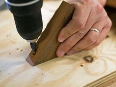 a person using a drill to cut wood