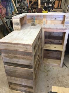 an unfinished desk made out of wooden pallets in a garage with lots of tools