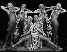 four women dressed in costume with beads and pearls