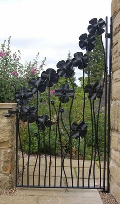 an iron gate with black flowers on it