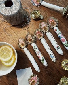 the table is covered with different types of decorative items and yarns, along with some lemon wedges