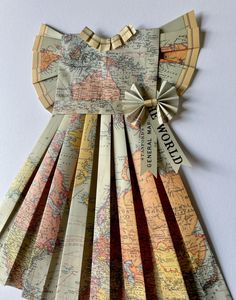 an origami world map dress made out of old maps with ribbon around the neck