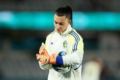 a female soccer player is holding her gloves