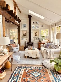 a living room filled with lots of furniture and rugs on top of a hard wood floor