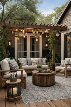 an outdoor living area with couches, tables and lights hanging from the ceiling above