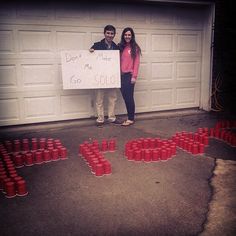 two people standing in front of a garage holding a sign