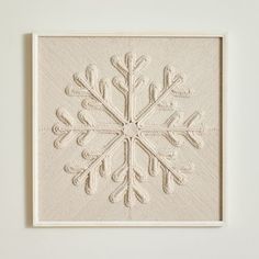 a white wall hanging with a snowflake design on it