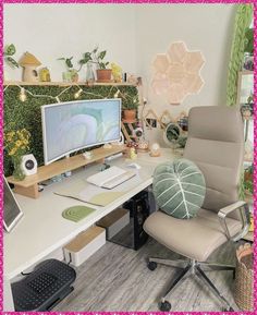 a desk with a computer monitor, keyboard and mouse on it in front of a pink frame