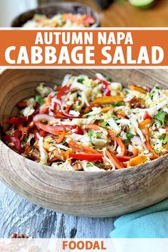 a wooden bowl filled with cabbage salad on top of a table