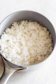 white rice in a bowl with spoon on the side