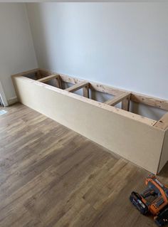 a room with hard wood flooring and an unfinished bench being built into the wall