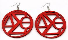 pair of red wooden earrings with symbols on them