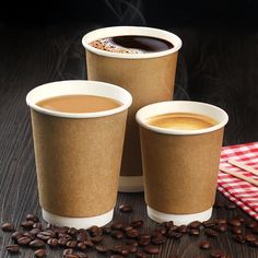 three coffee cups sitting on top of a wooden table