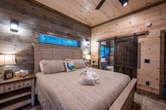 a bedroom with wood paneling and white bedding