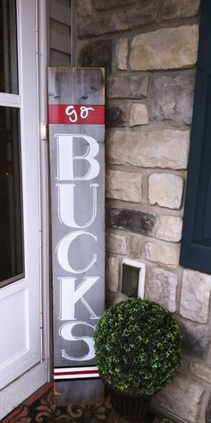 a sign that is on the side of a building next to a potted plant