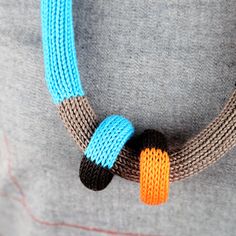 a knitted necklace with two different colored beads