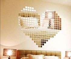 a bedroom with a heart shaped mirror on the wall above the headboard and bed