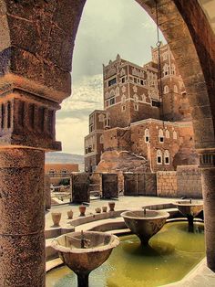 an old building with fountains in front of it and water running through the courtyards