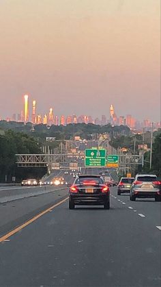 cars are driving down the highway with city lights in the background