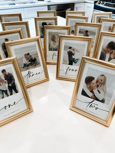 a table topped with lots of framed pictures