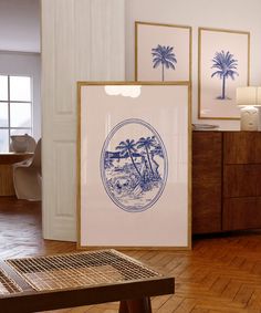 there is a blue and white print on the wall next to a wooden table in front of two framed pictures