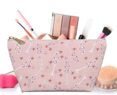 a pink cosmetic bag filled with makeup and other beauty products on a white background,