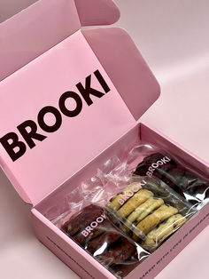 a pink box filled with cookies on top of a table