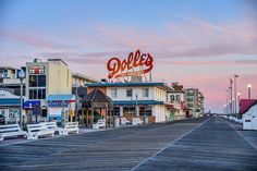 the boardwalk is lined with shops and restaurants at dusk in ocean city, new jersey