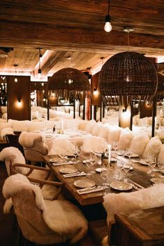 a dining room filled with lots of tables covered in white blankets and furry chairs next to each other