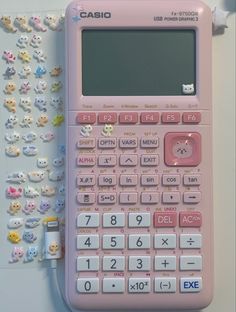 a pink calculator sitting on top of a table next to many small teddy bears