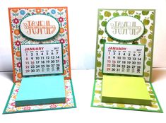 two cards with calendars on them sitting next to each other