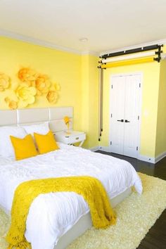 a bedroom with yellow walls and white bedding