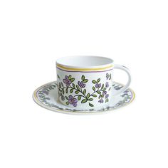 a cup and saucer with flowers painted on it