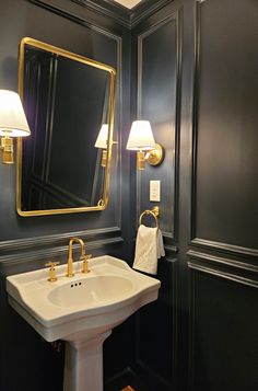 a white sink sitting under a bathroom mirror next to a wall mounted faucet