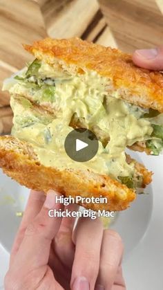 a person holding up a sandwich in front of the camera with text that reads high protein chicken biscuit mac