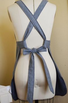 a white mannequin with a blue ribbon tied around it's waist and back