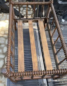 a bed frame made out of metal and wood with springs on the bottom, attached to an iron grate