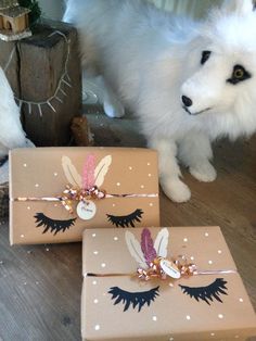 two boxes with designs on them are sitting on the floor next to a white dog