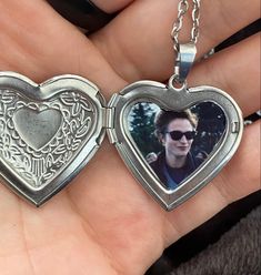 two silver heart shaped lockes with a photo inside