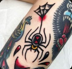 a tattoo on the leg of a person with a spider and bird design around it