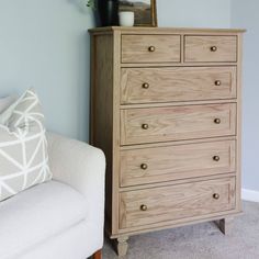 a wooden dresser sitting next to a white couch