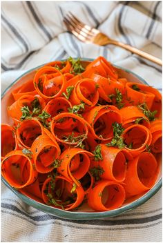 a bowl filled with sliced carrots on top of a table