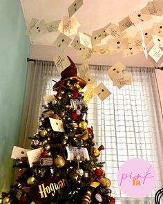 a decorated christmas tree with lots of paper notes hanging from it's top and bottom