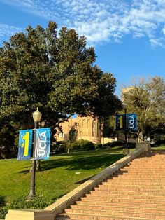 the steps lead up to an old building with banners on it and trees in the background