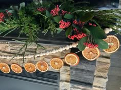 an arrangement of oranges and berries on a mantel